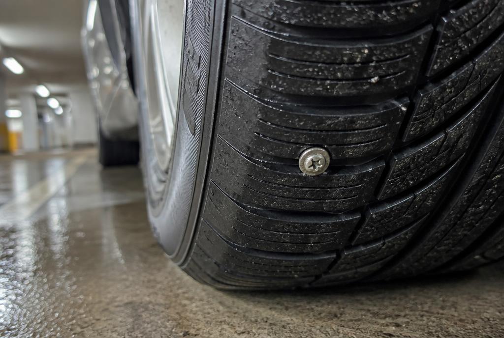 Roofing screw stuck in the tread of a car tyre